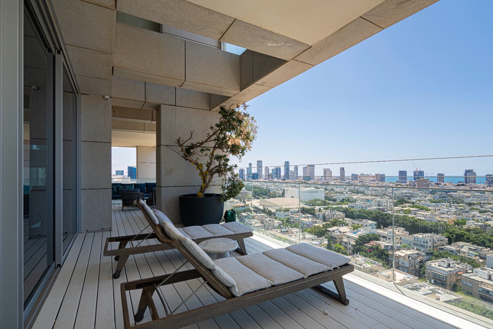 Terrace loungers above the rooftops of Tel Aviv, the sea on the horizon