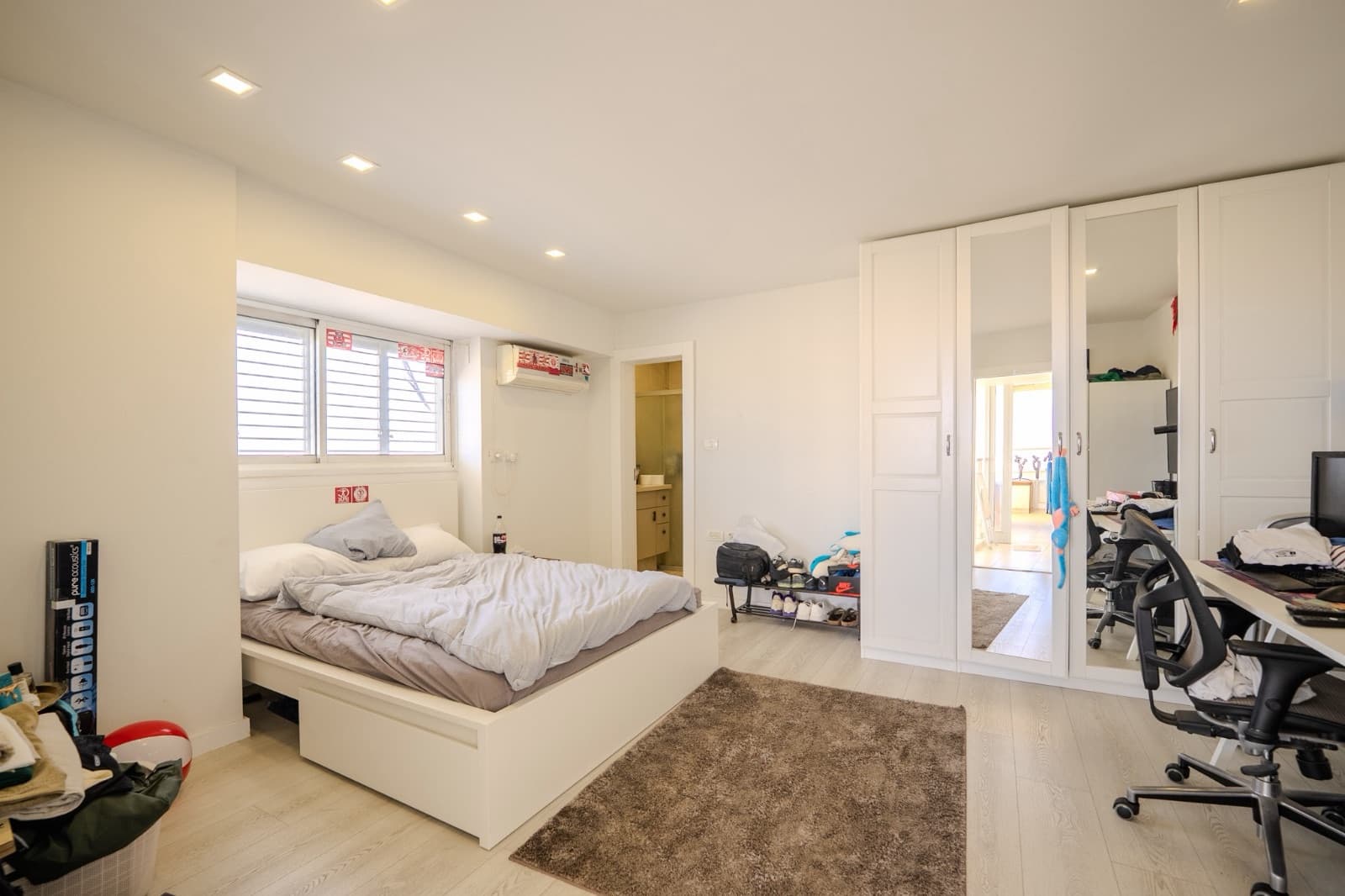Bedroom with fitted white wardrobes and en-suite bathroom beyond