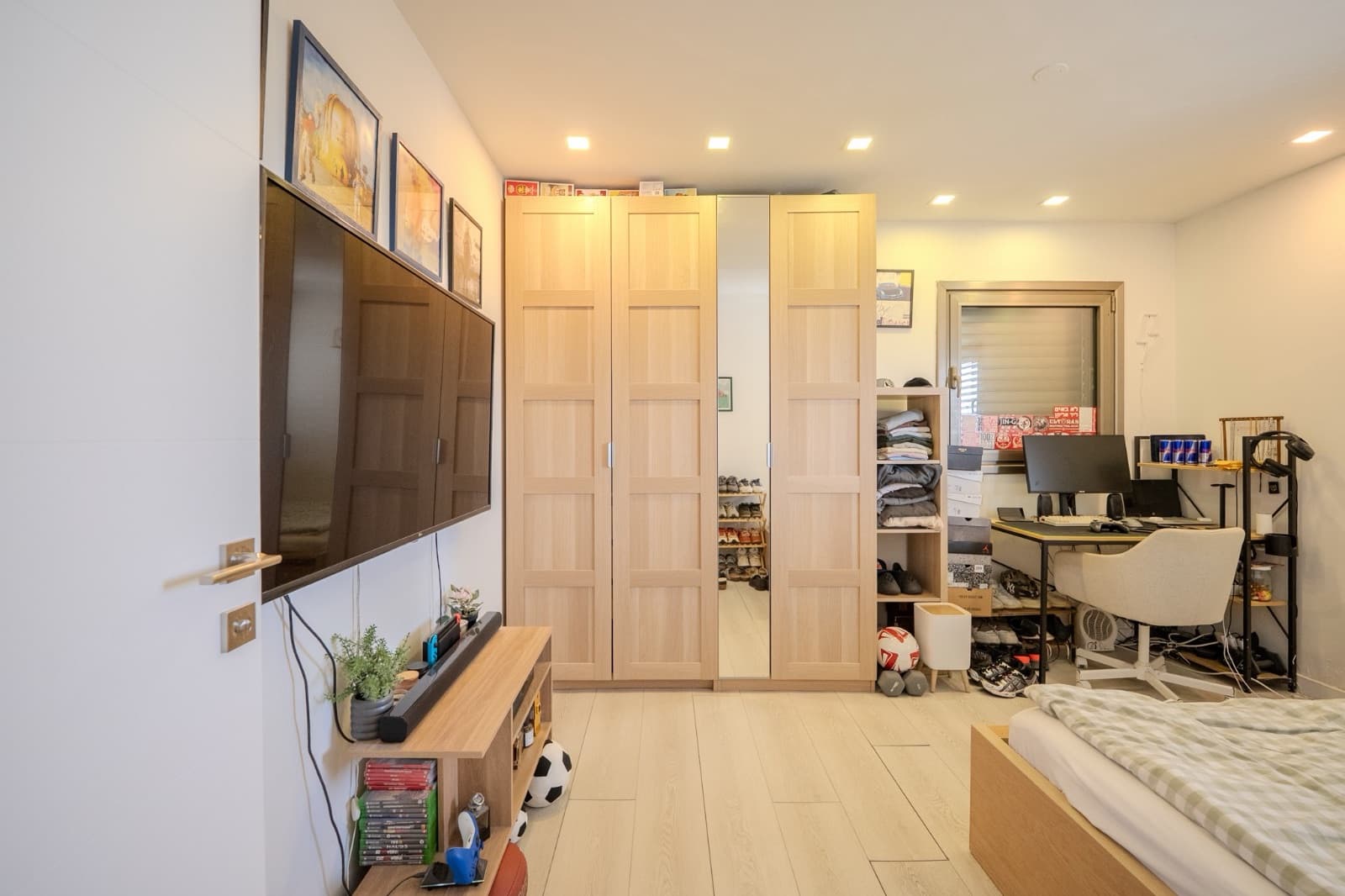 Bedroom arranged with wardrobes, desk and media wall