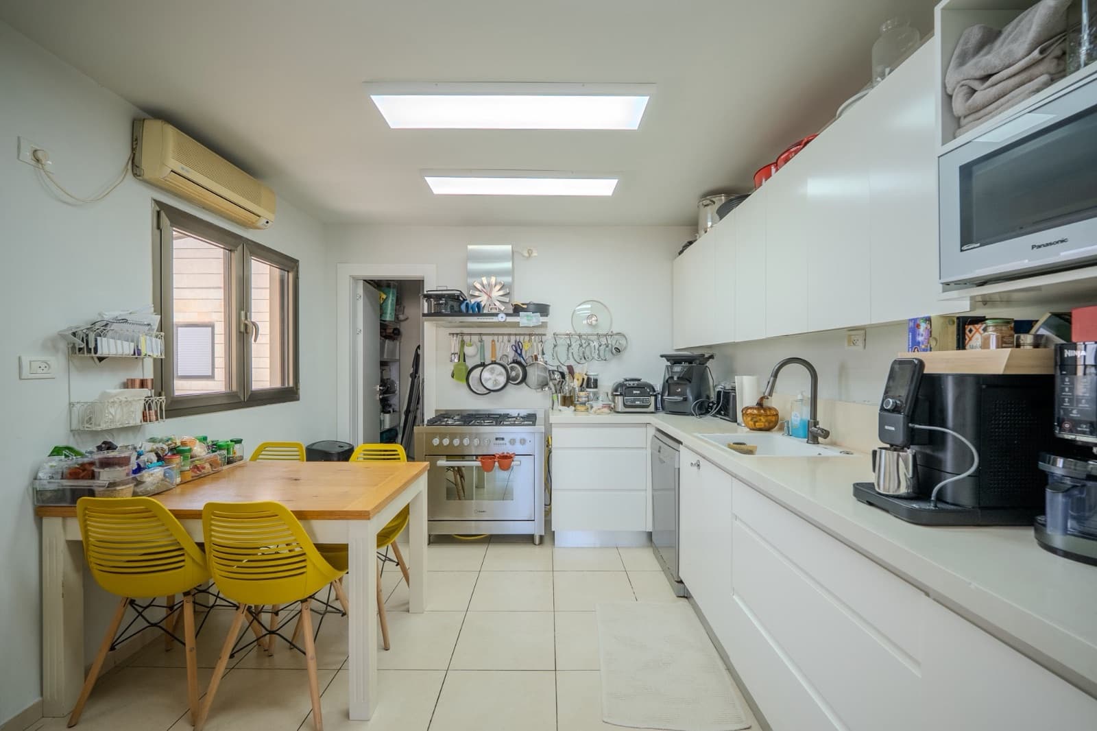 White kitchen with breakfast table and full cooking range