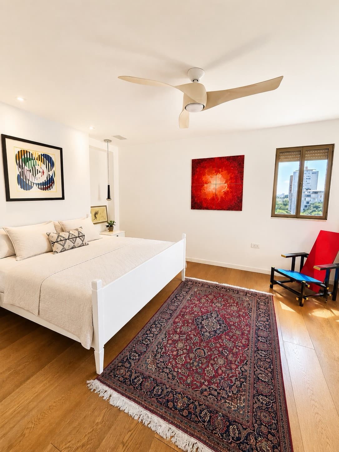 White bedroom with Persian rug and curated artwork